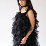 A side view of a woman wearing the light as a feather puff dress.