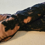 Pumpkin draped in dark lacy material beside Fleur Embroidered Gloves for a seasonal touch