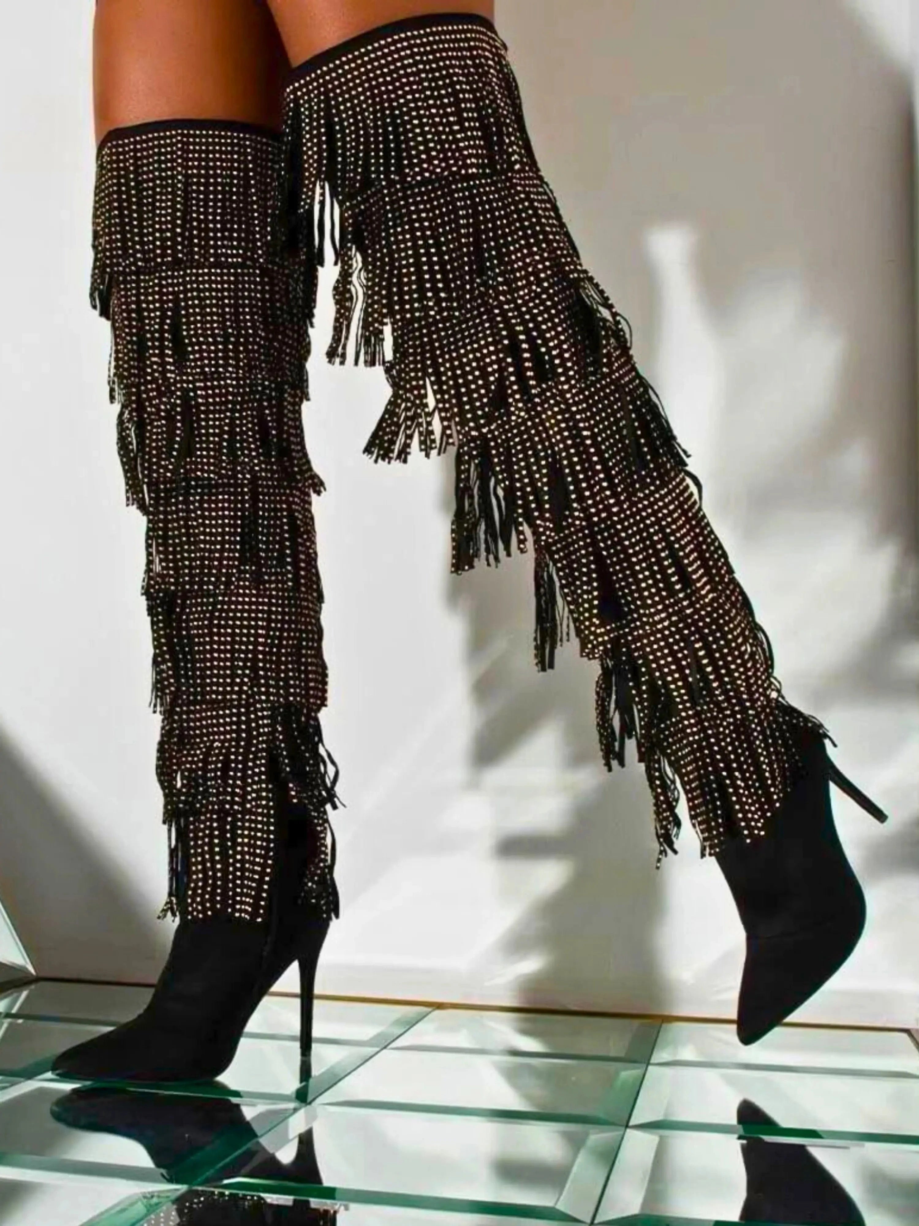 The Fringe Thigh High Boots by Azalea Wang with gold studded fringe and stiletto heels, styled for a bold over-the-knee fashion statement.