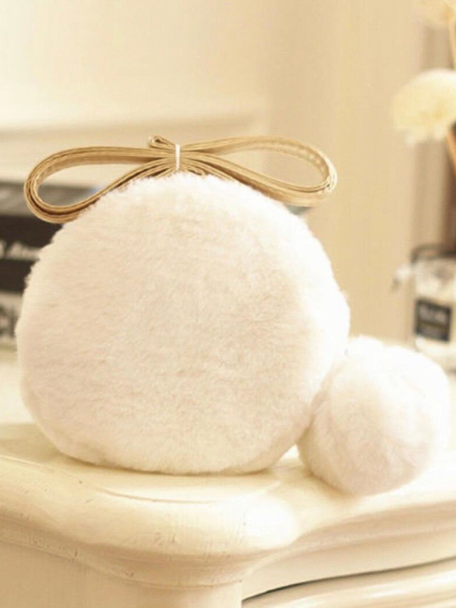 Fluffy white pom pom micro purse with a beige bow on top for stylish flair