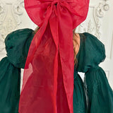 Large red bow on dark green fabric, showcasing the stunning Giant Flutter Bow design