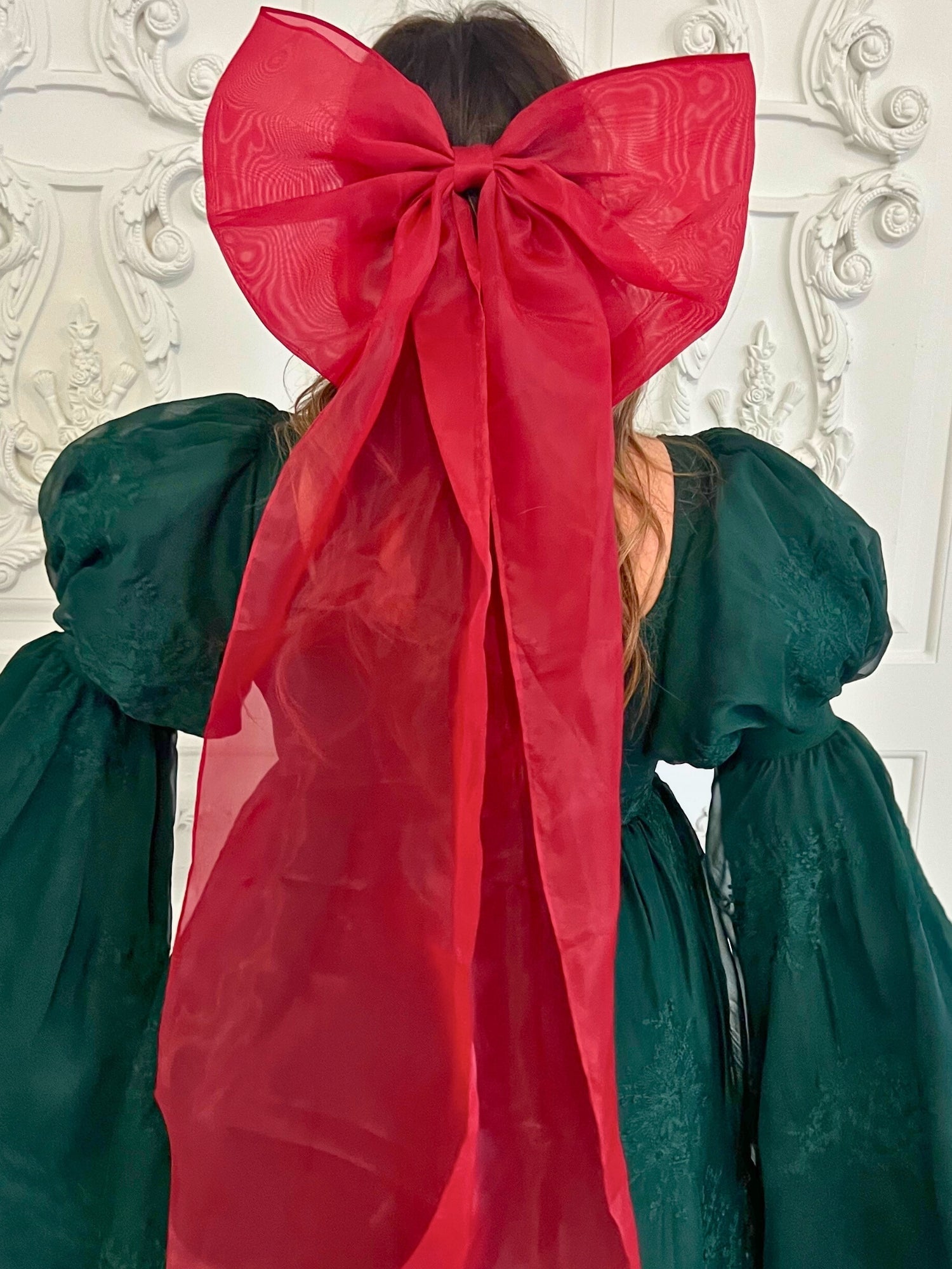 Large red bow on dark green fabric, showcasing the stunning Giant Flutter Bow design