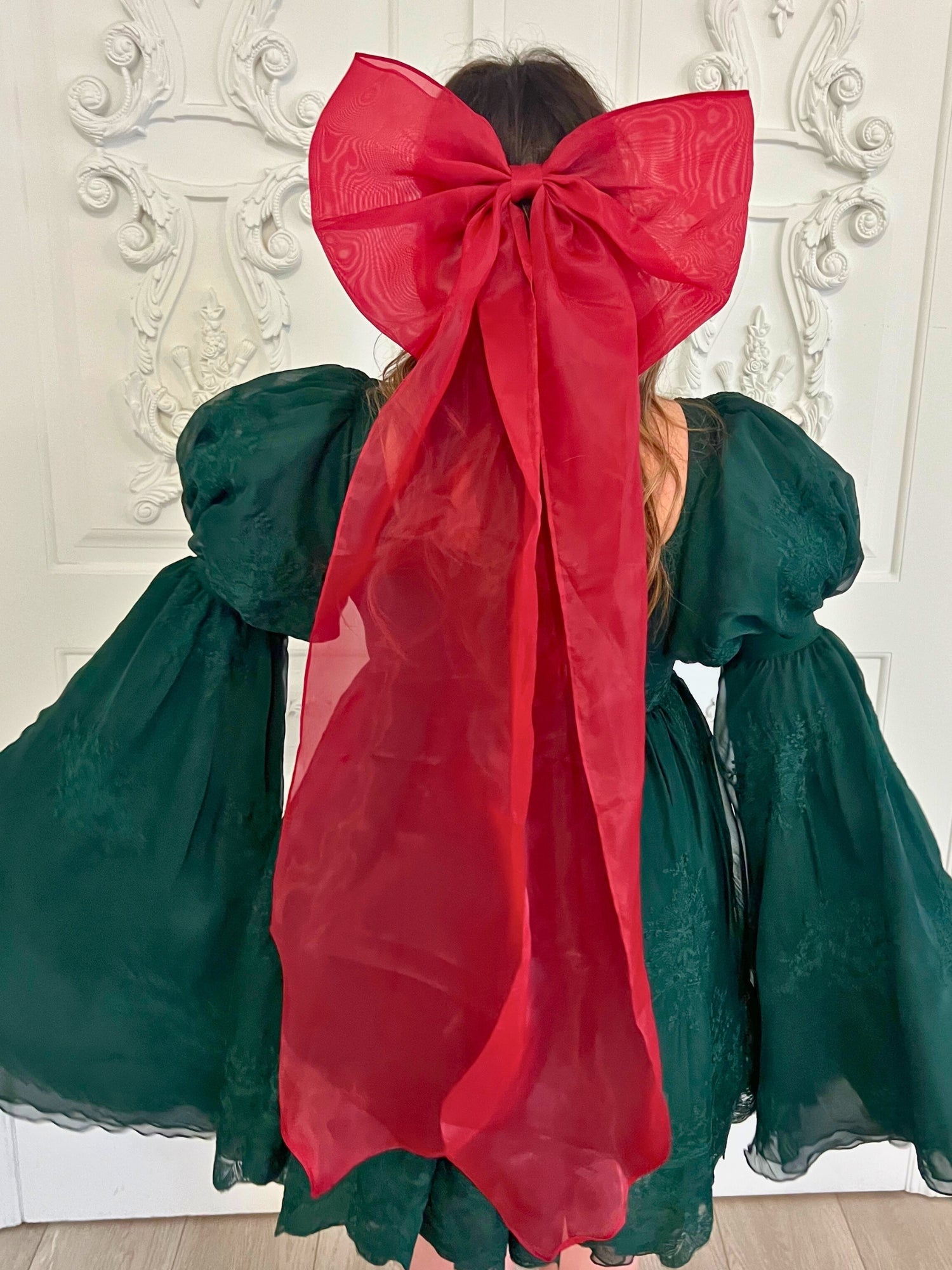 Festive dress featuring a green bodice and large red bow from The Giant Flutter Bow