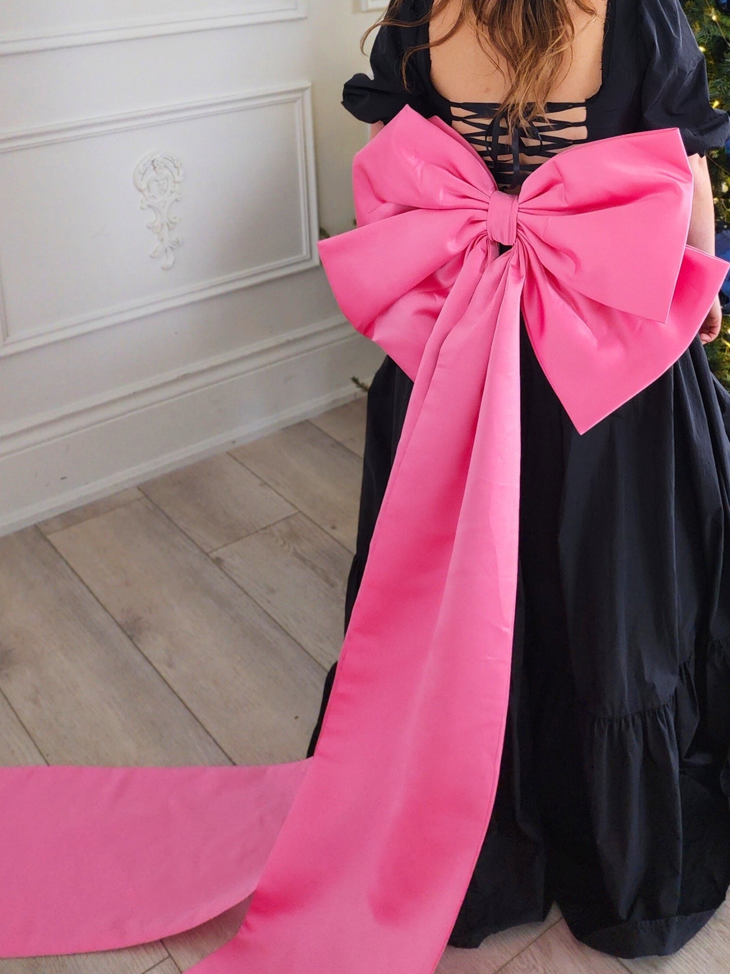 Bright pink oversized bow on black dress from The Grand Bow Sash for bow lovers