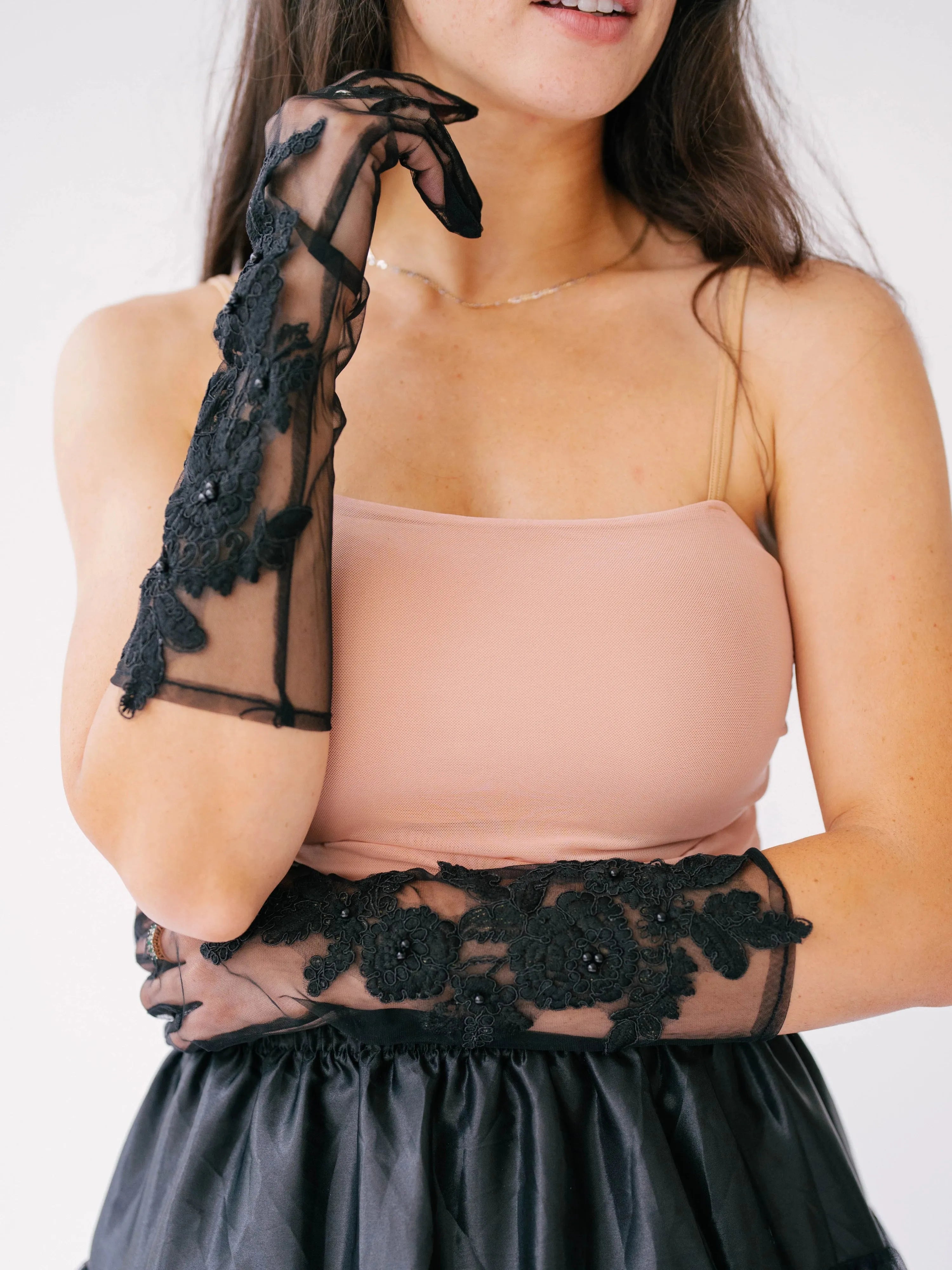 Regal long black lace gloves paired with a peach strapless top.