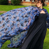 Flowing blue floral High Priestess Cape billowing in the wind