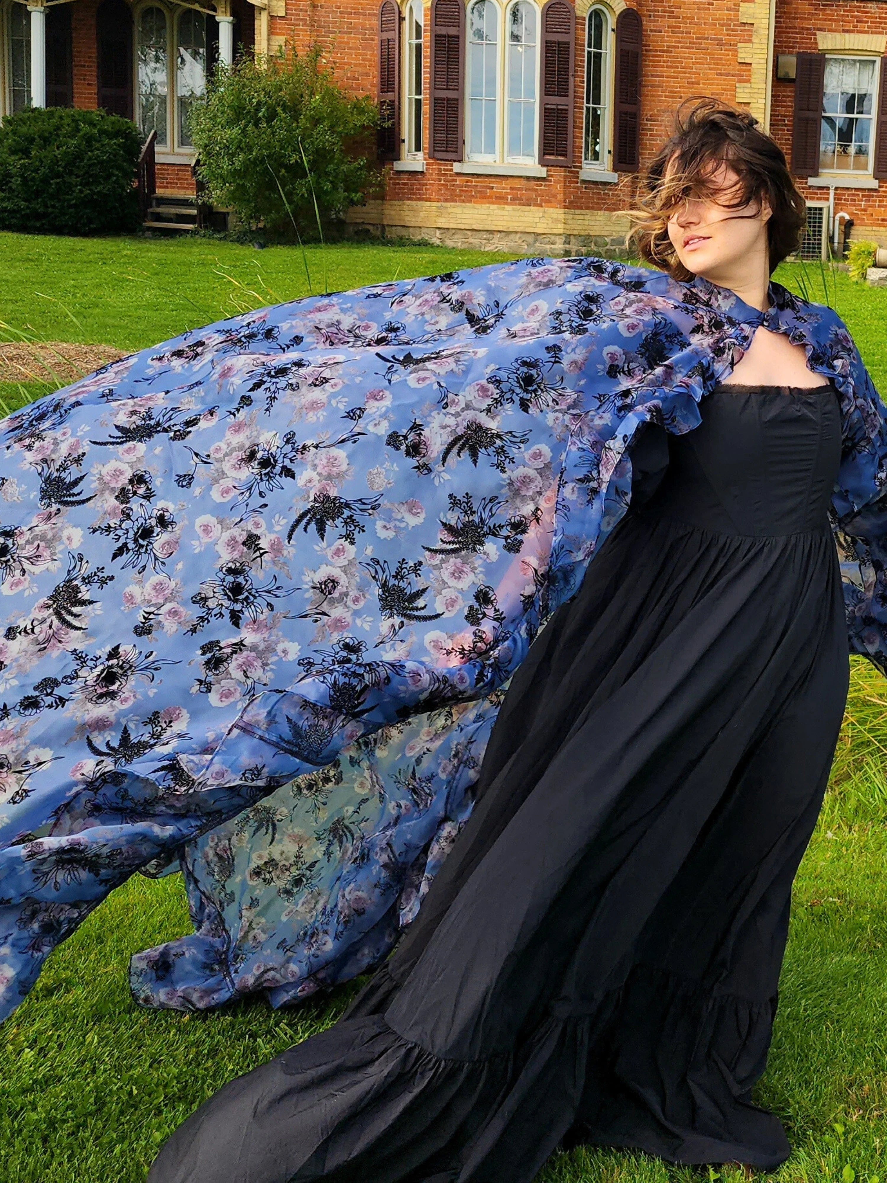 Flowing blue floral High Priestess Cape billowing in the wind