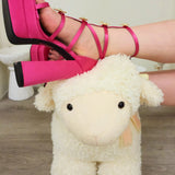 Hot Pink Platform Heels worn by woman resting her feet on a cute white sheep toy rocking chair.
