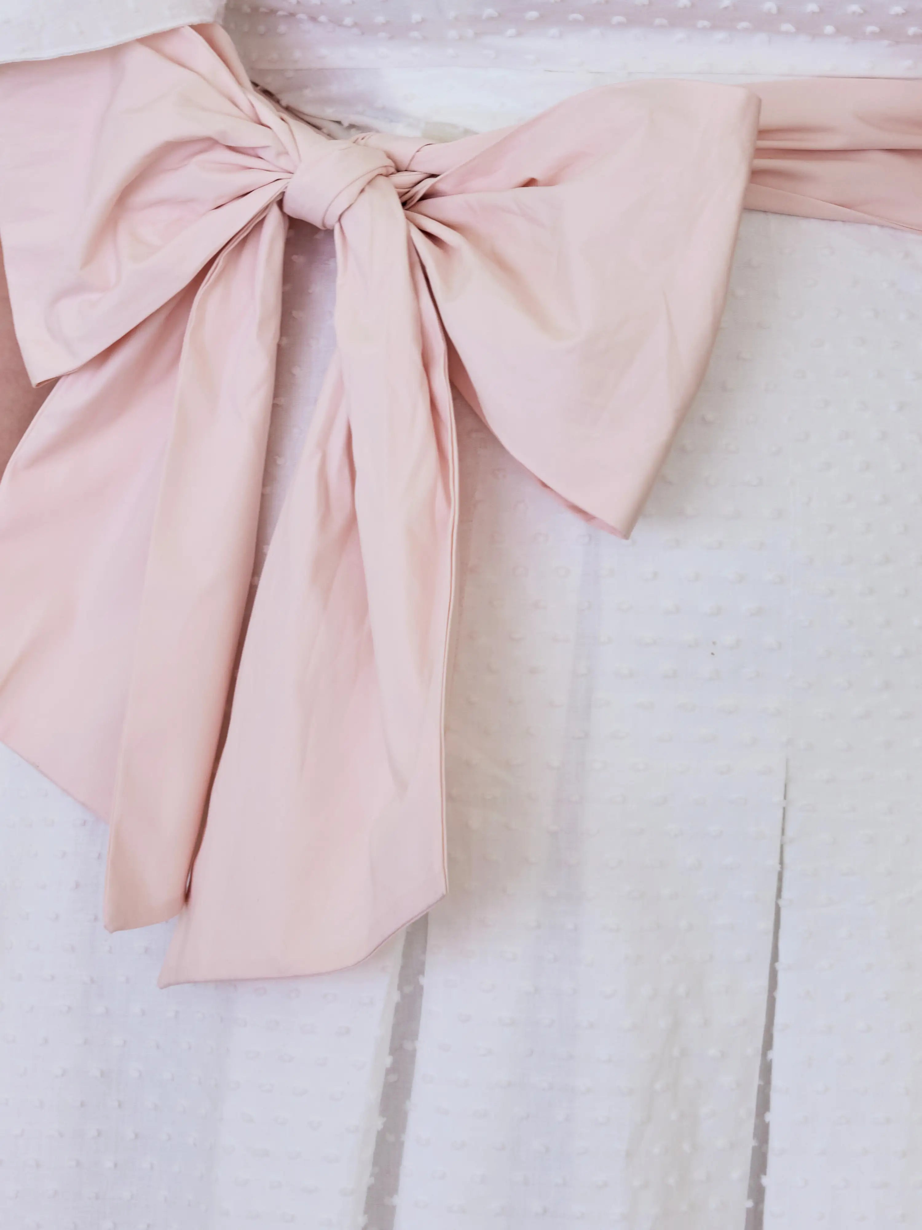 Pale pink fabric bow tied in a decorative knot on the Ivory Cloud Midi Dress