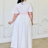 Woman in Ivory Cloud Midi Dress with flutter sleeves and pink waistband, back view