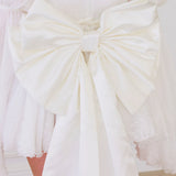 White fabric bow on The Ivory Grand Bow Sash embodies whimsical elegance