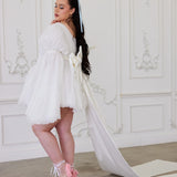 White short wedding dress with long train and puffy sleeves, showcasing whimsical elegance with a Grand Bow Sash