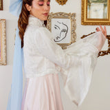 Woman wearing The Ivory Lady Elizabeth Bolero Jacket in front of framed artwork