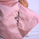 A close up of Ivory Sheep's Dolls Revolt Pink Hair Bow with embroidery saying "the dolls revolt"