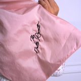 A close up of Ivory Sheep's Dolls Revolt Pink Hair Bow with embroidery saying "the dolls revolt"