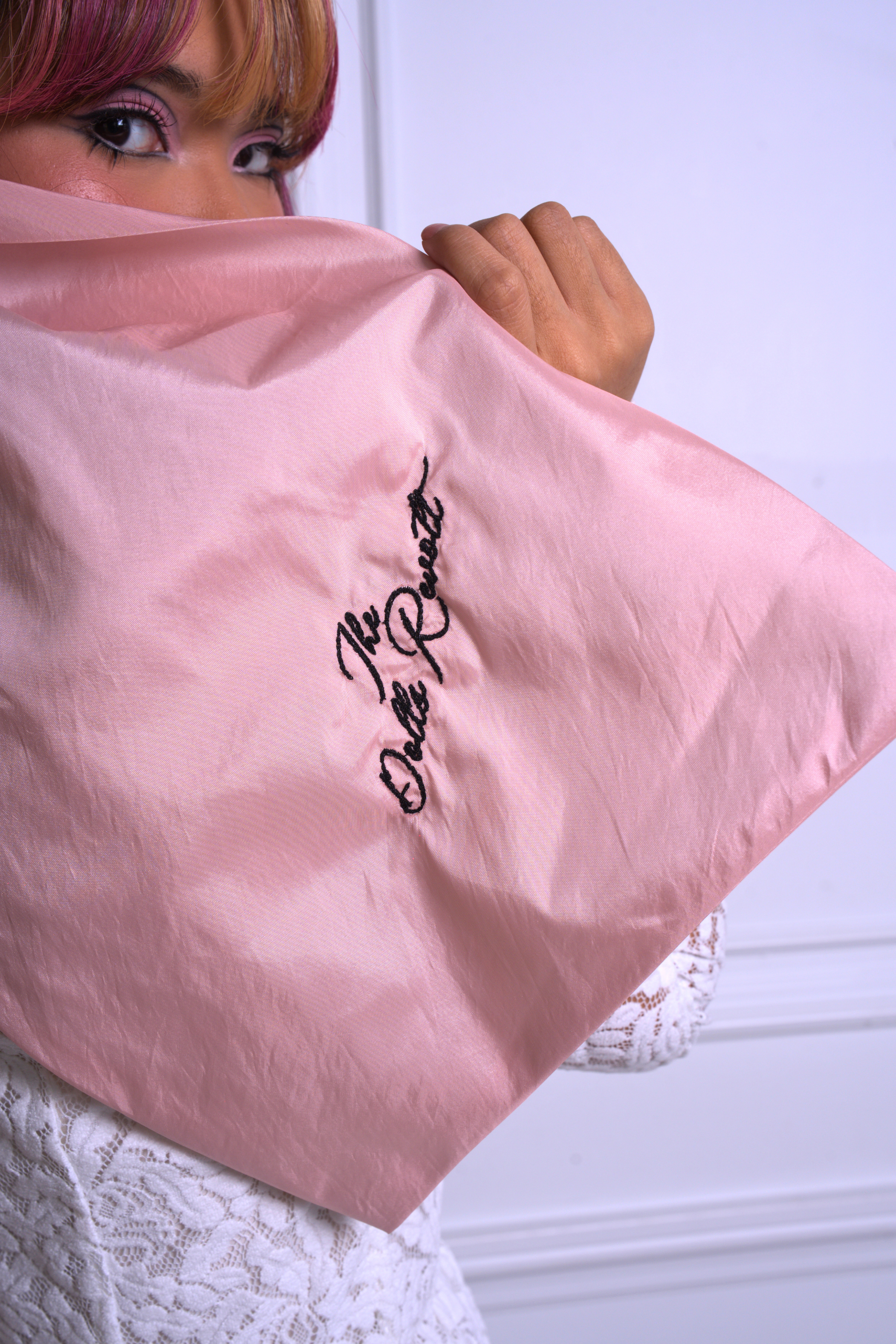 A close up of Ivory Sheep's Dolls Revolt Pink Hair Bow with embroidery saying "the dolls revolt"