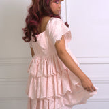 A woman wearing Ivory Sheep's Leighton Pink Cotton Mini Dress against a white background