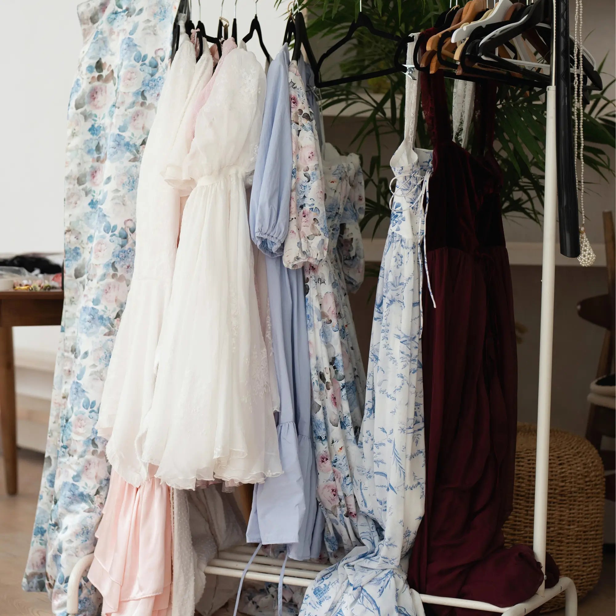 Multiple Ivory Sheep dresses and gowns on a clothing rack in a brightly lit room.