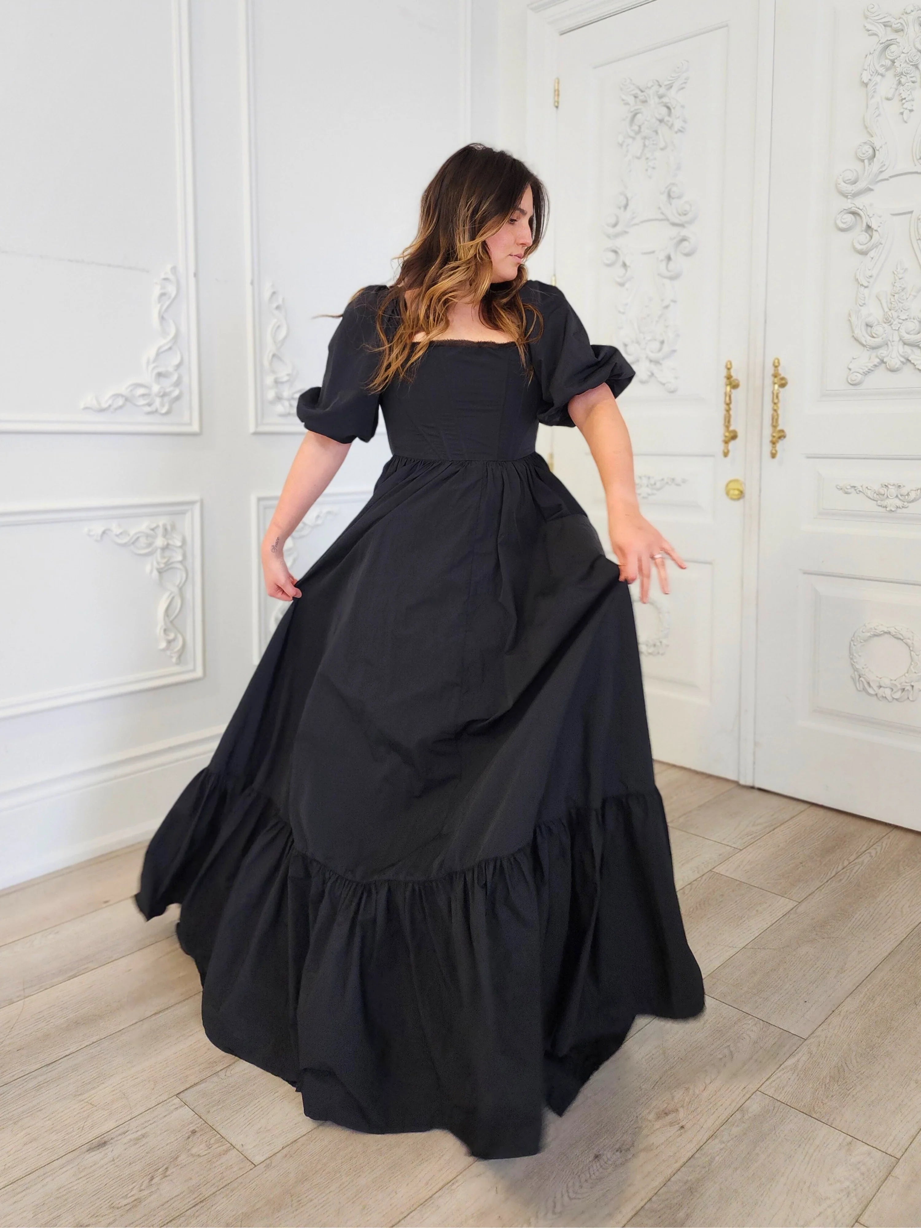 Long black Josephine Gown featuring classic puff sleeves and a tiered skirt design