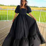 Long black Josephine Gown featuring classic puff sleeves and a meticulously structured skirt