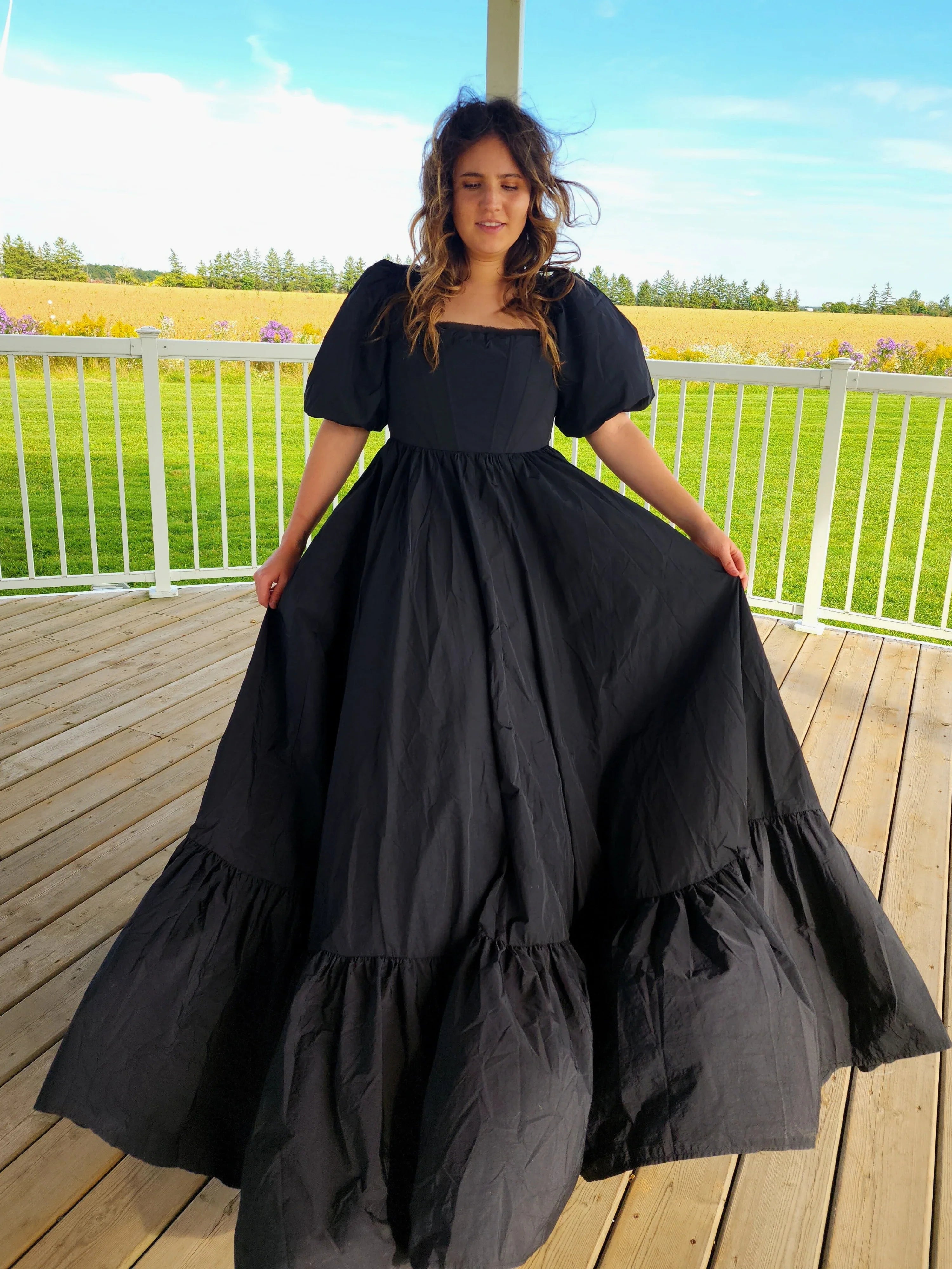 Long black Josephine Gown featuring classic puff sleeves and a meticulously structured skirt