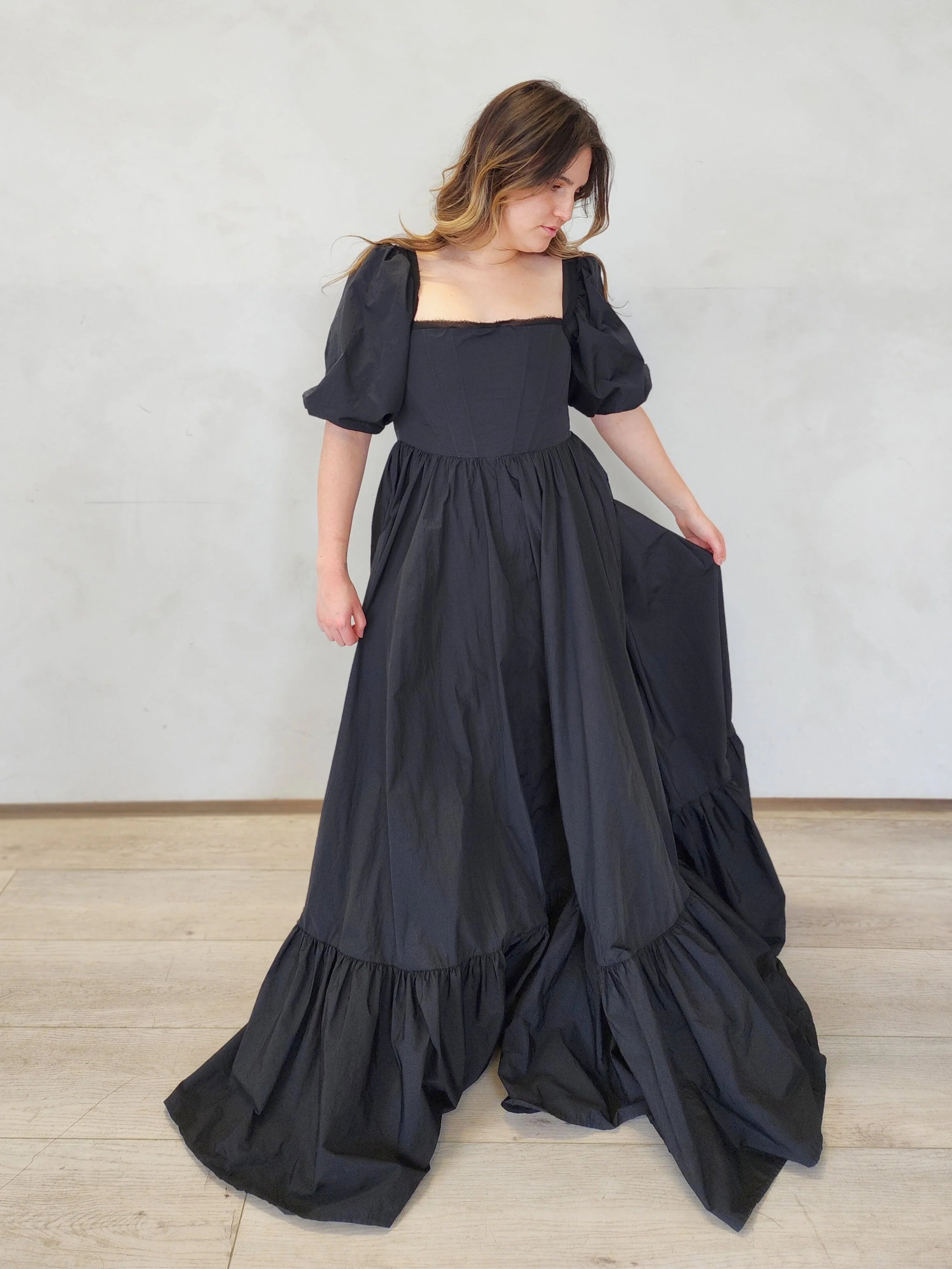 Long black Josephine Gown featuring classic puff sleeves and a tiered, ruffled skirt