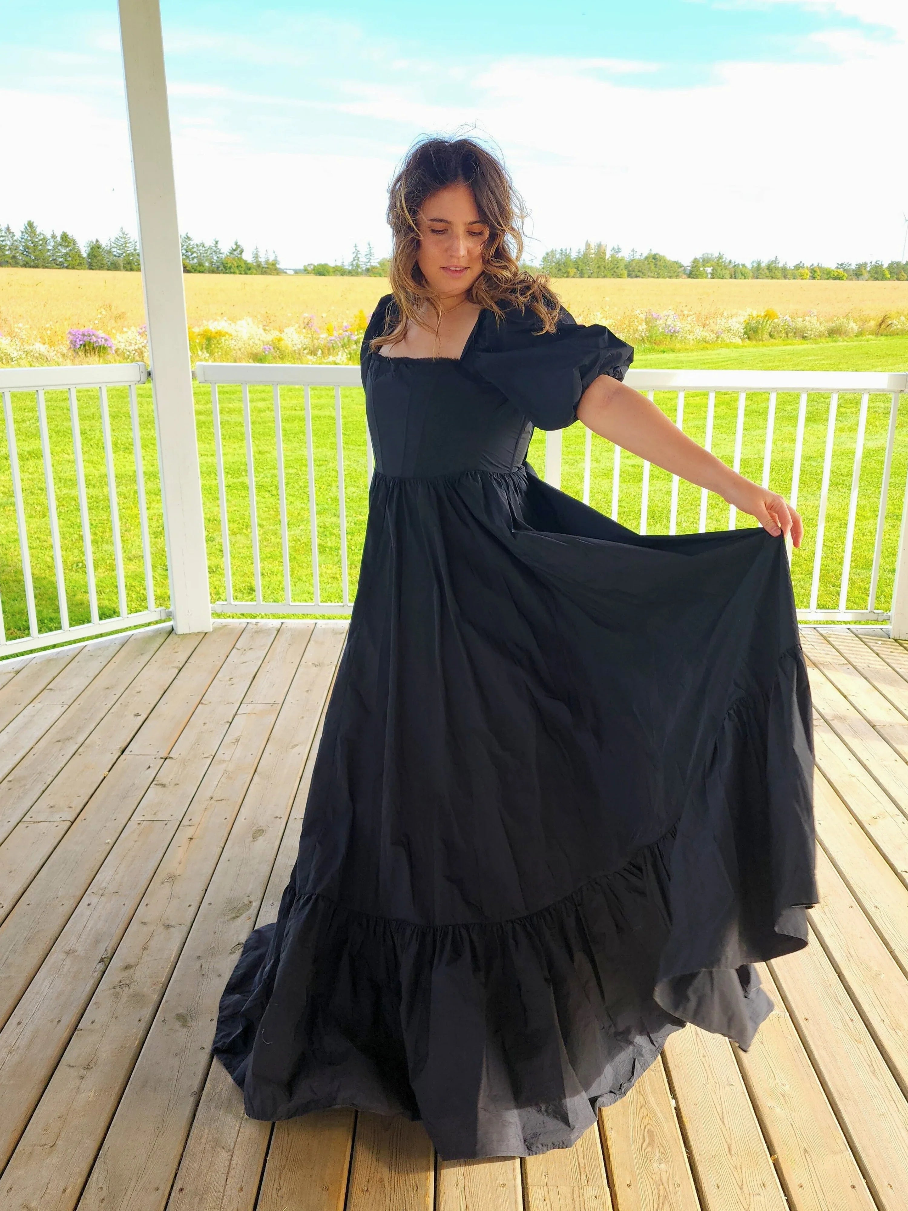 Woman in The Josephine Gown with classic puff sleeves on a wooden porch