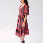 Side view of a woman wearing the Josephine tartan plaid dress against a white background.
