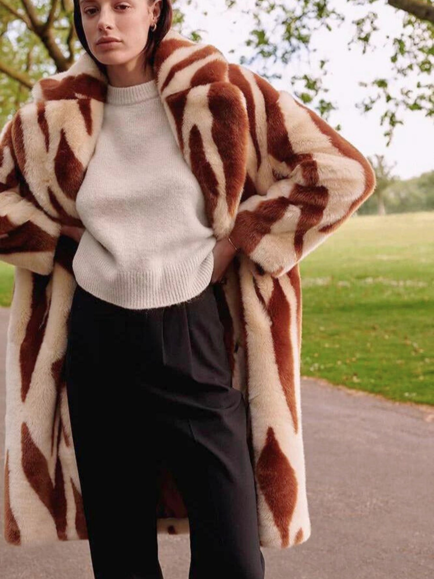 Katie Faux Fur Chestnut Tiger Duster Coat over sweater and dark pants with abstract shapes