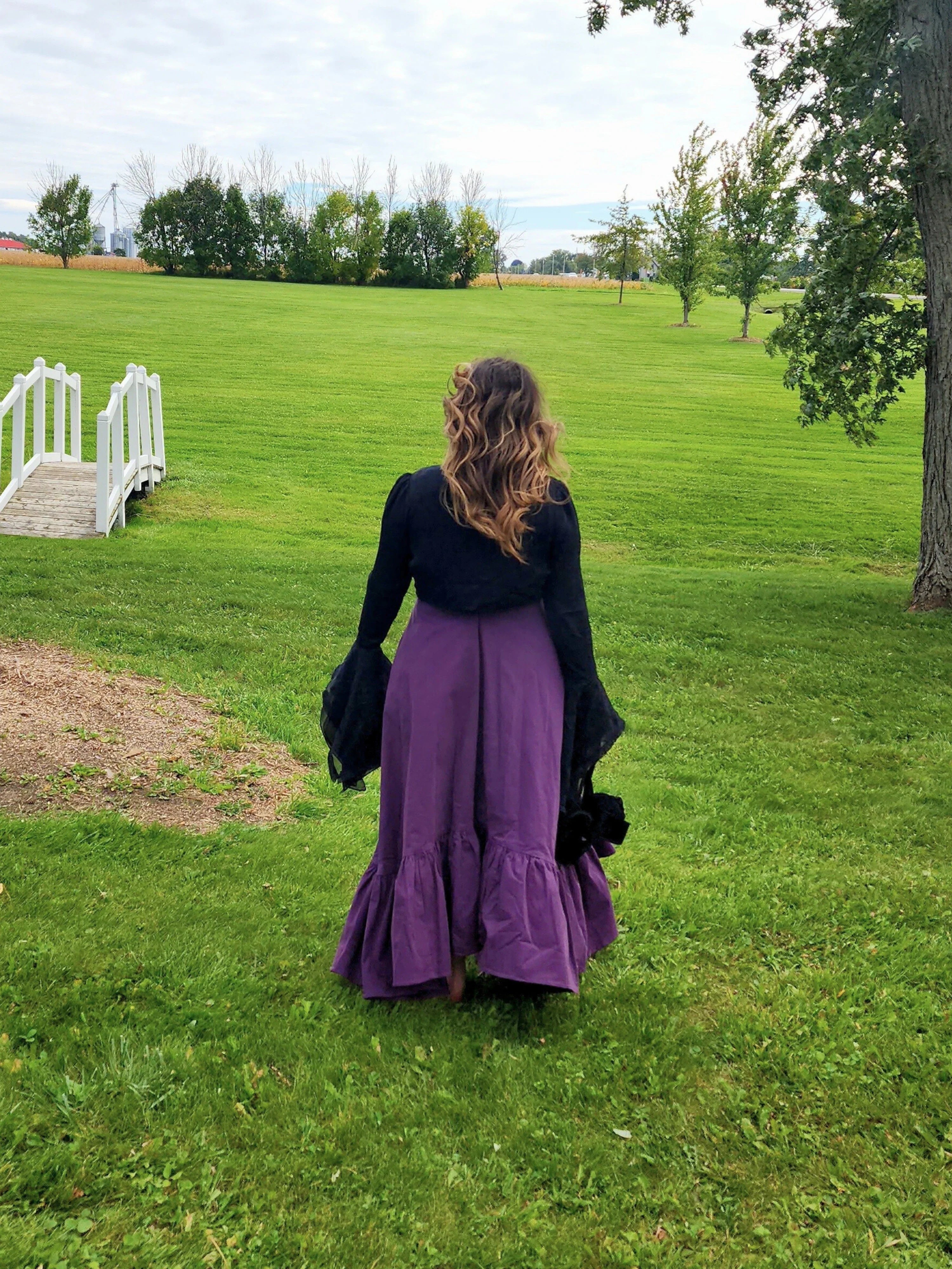 Woman in a long purple skirt and black top showcasing the Lady Elizabeth style