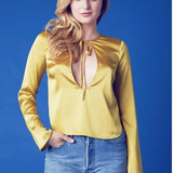 Woman in a lemon meringue long sleeved blouse and blue jeans, showcasing vibrant style