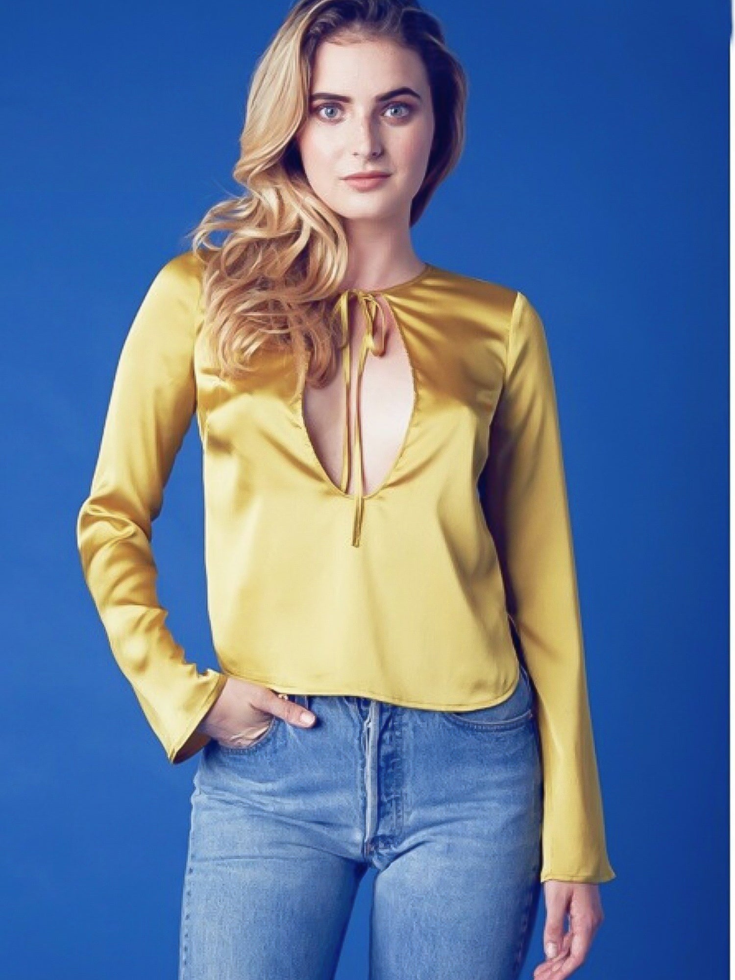 Woman in a lemon meringue long sleeved blouse and blue jeans, showcasing vibrant style