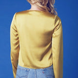 Yellow long sleeved blouse styled with blue denim shorts for a chic summer look