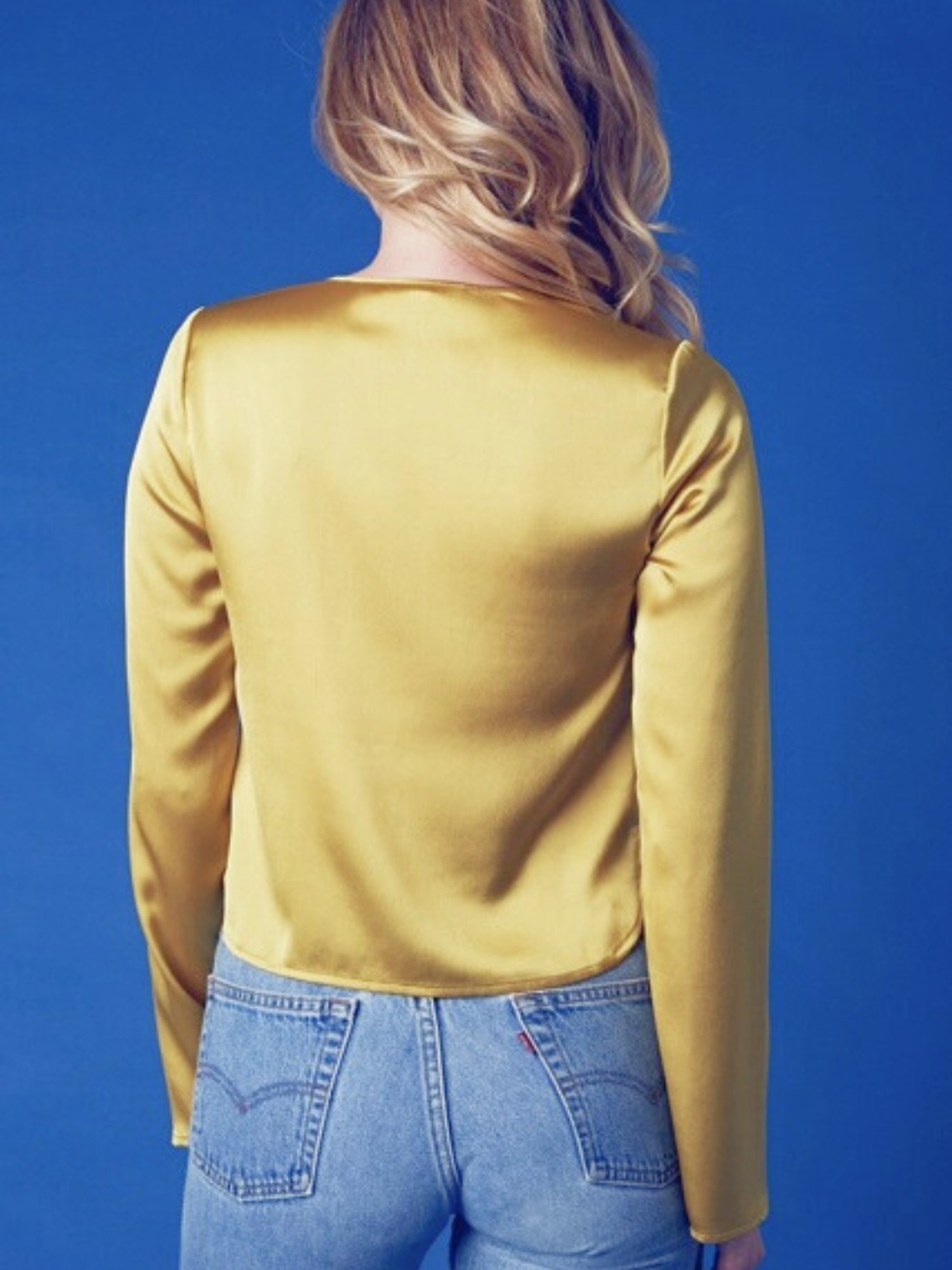 Yellow long sleeved blouse styled with blue denim shorts for a chic summer look