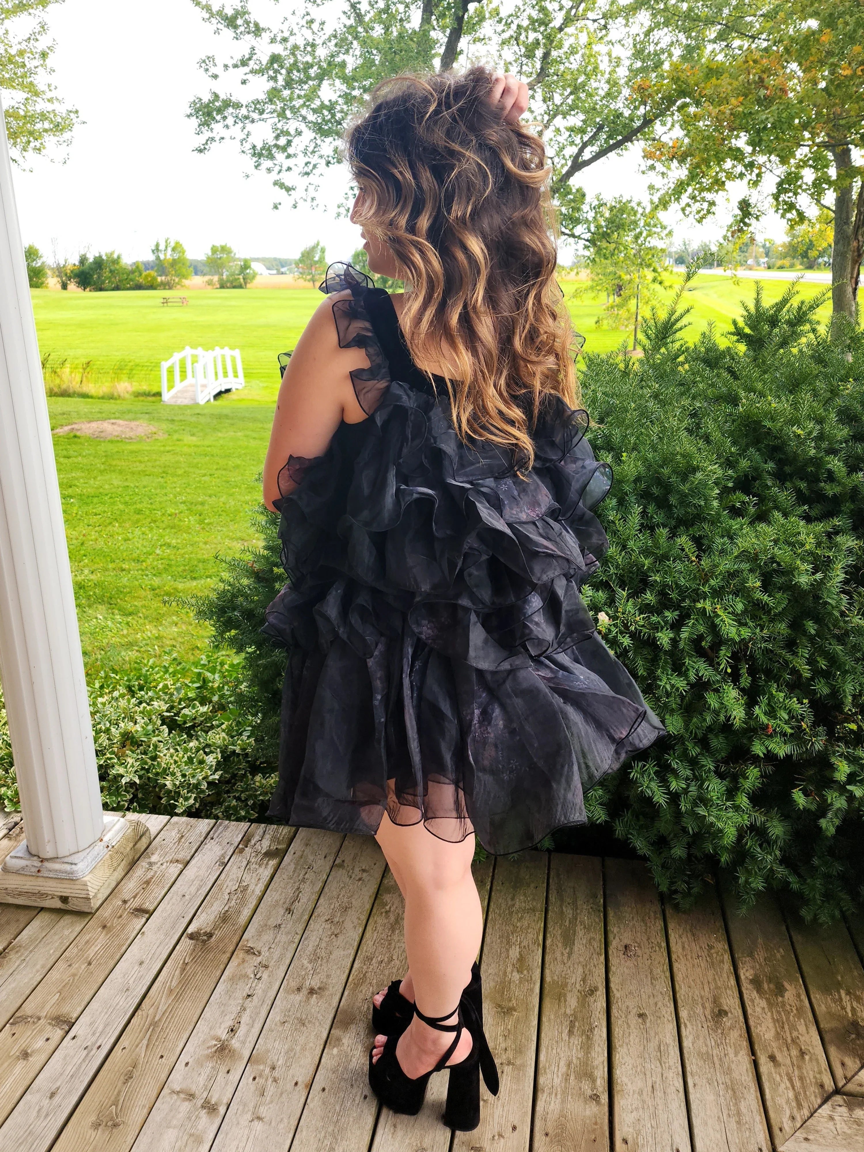 Frilly black feather mini dress with ruffled layers and off-shoulder design