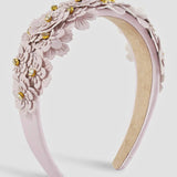 Lilac floral headband with gold accents on a light gray background.
