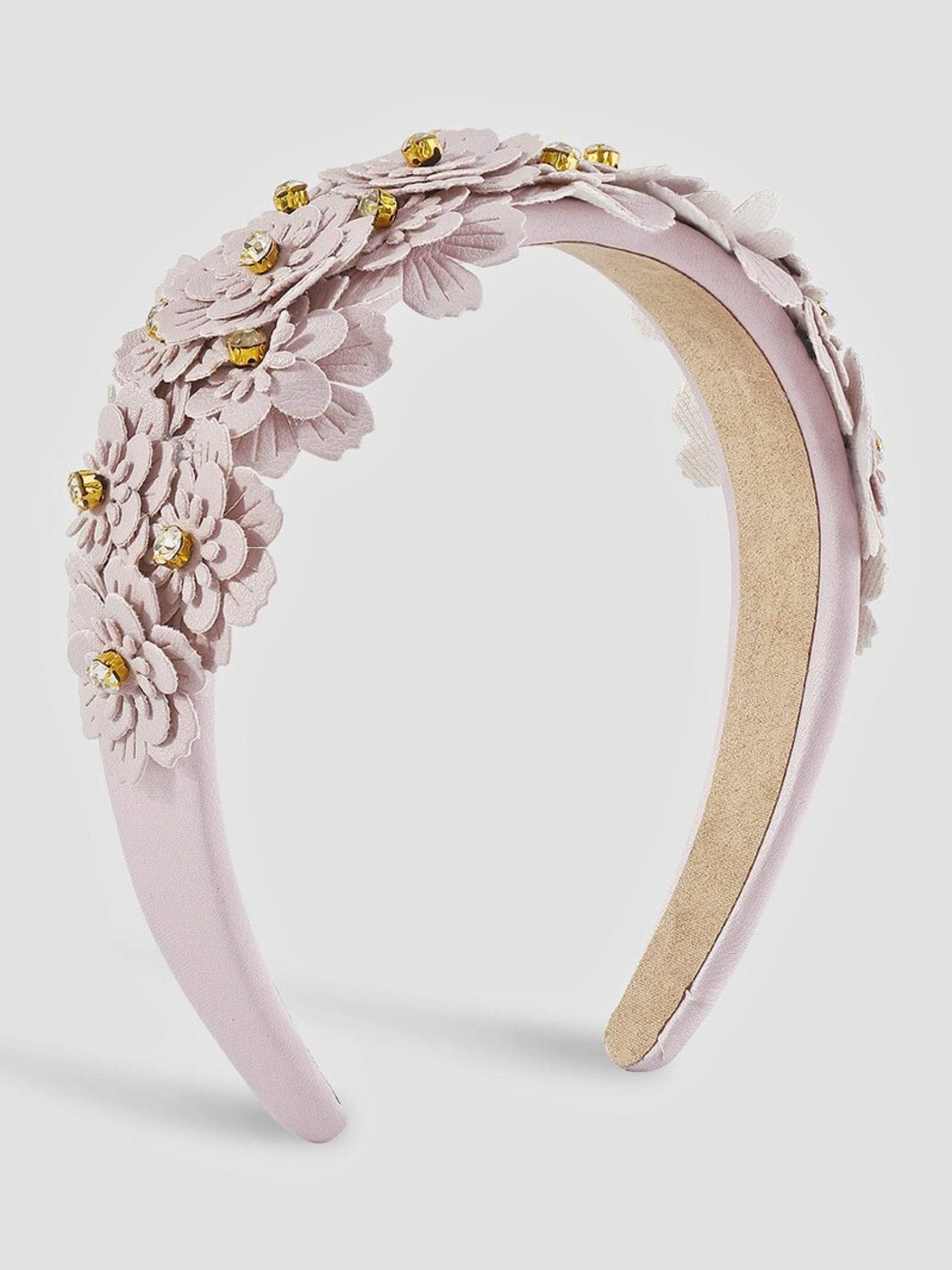Lilac floral headband with gold accents on a light gray background.