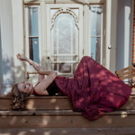 The Scarlet Red Scorned Lovers Gown styled outdoors, featuring a flowing red chiffon skirt and corset bodice, evoking Victorian romance.