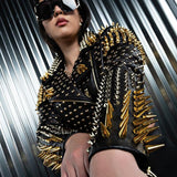 Person in a spiked Lucifer Gold Studded Jacket and oversized sunglasses