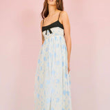 Woman in Ocean Blues Cami Midi Dress featuring a black bodice and blue patterned skirt