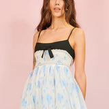 Woman in Ocean Blues Cami Midi Dress with floral design and black bow detail