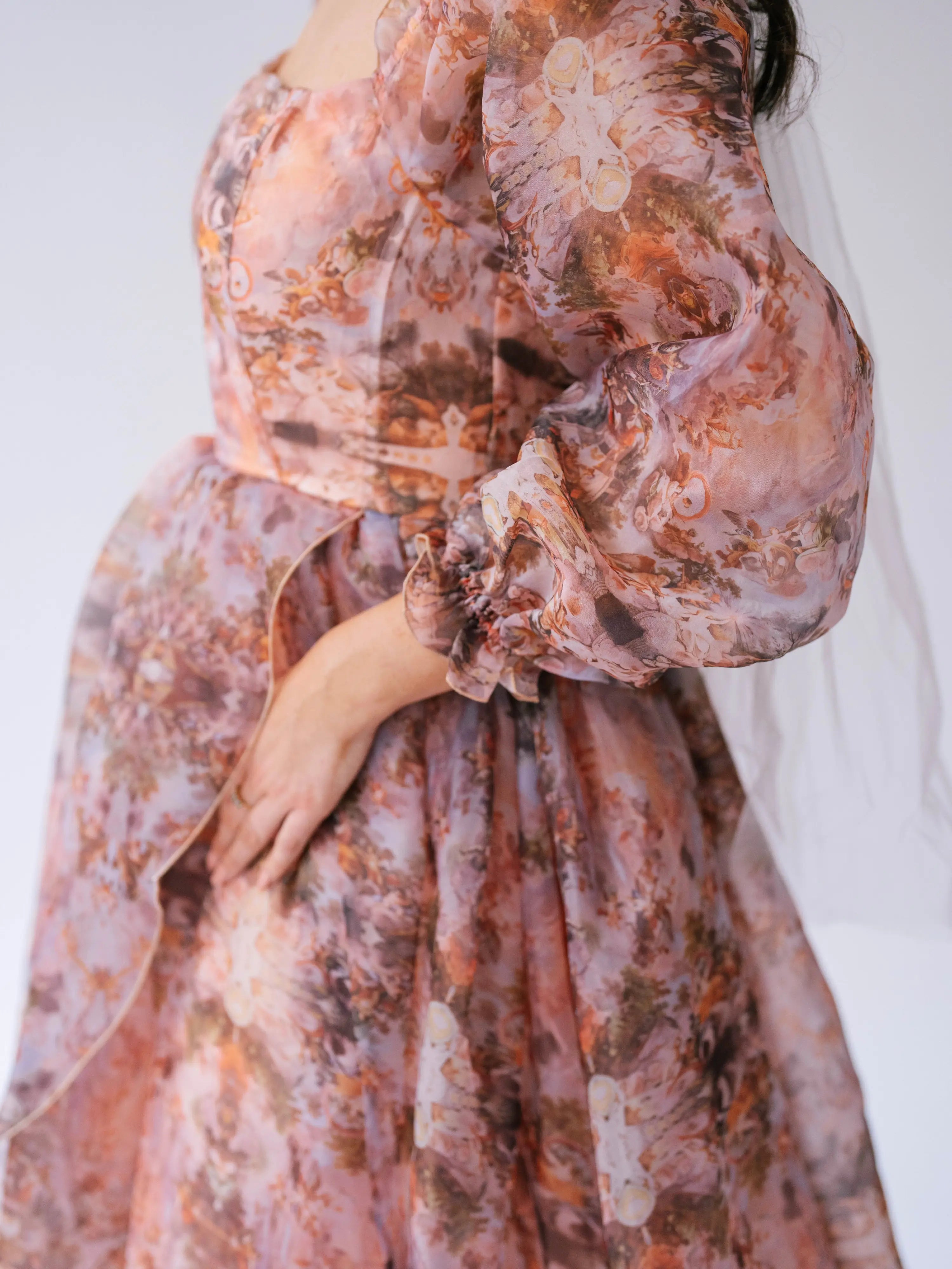 Ball Gown in soft peach and brown tones with sheer, billowing sleeves.