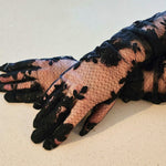 Elegant hand sewn opera gloves in black lace with floral patterns over nude fabric