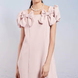 Paddle Bow Mini Dress featuring a pale pink color and bow-adorned puff sleeves