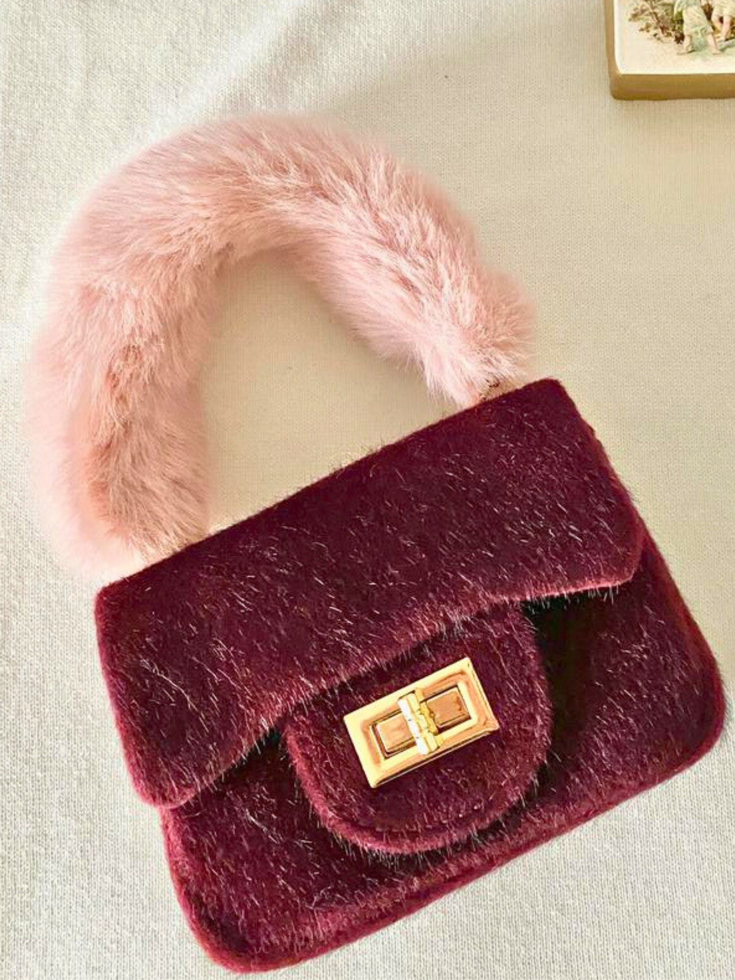 Burgundy velvet Petit Agneau micro handbag with fluffy pink faux fur handle and gold clasp