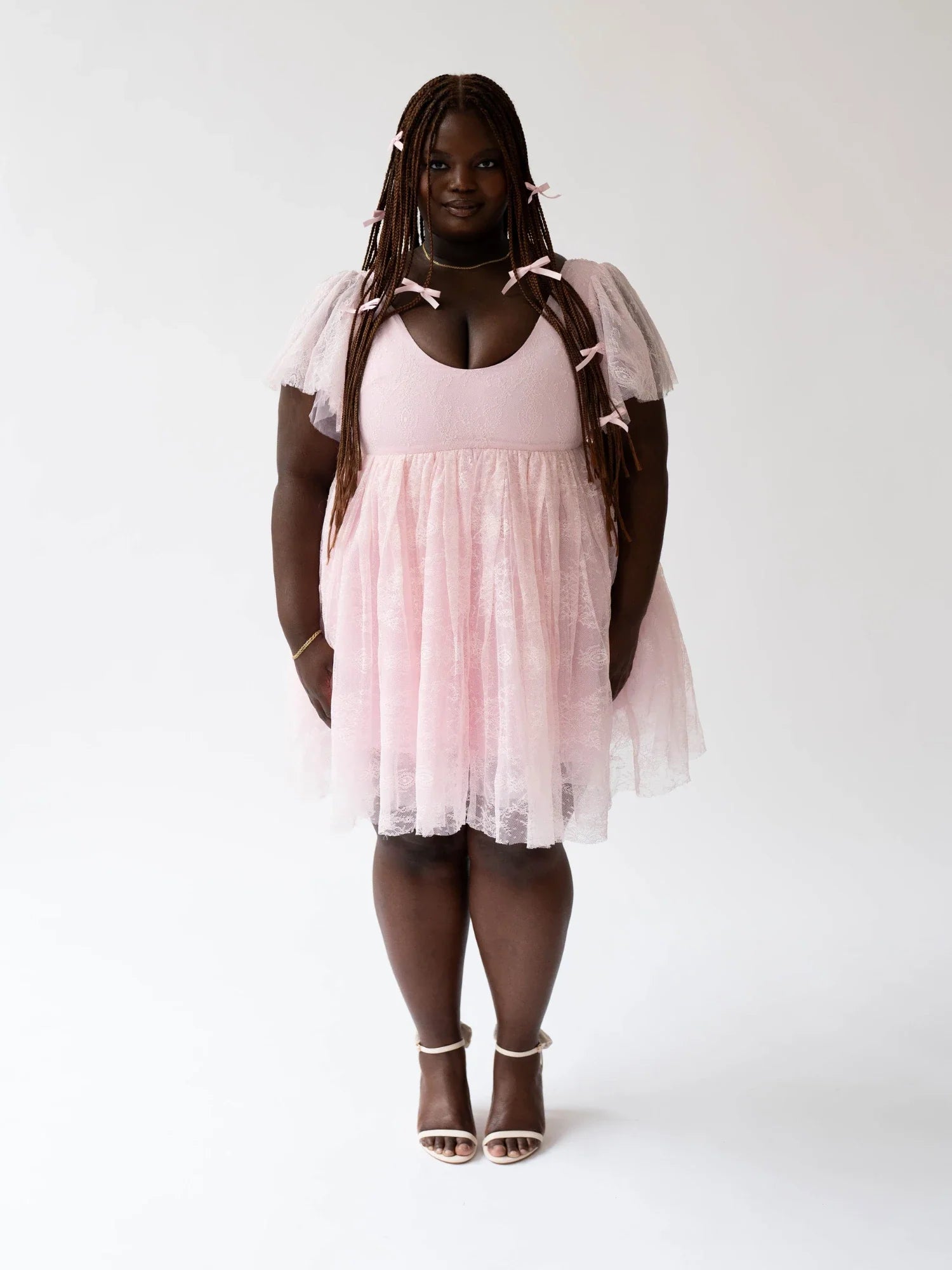 Woman with dreadlocks in a Pink Candy Cherub Dress featuring a fitted bodice and flared skirt