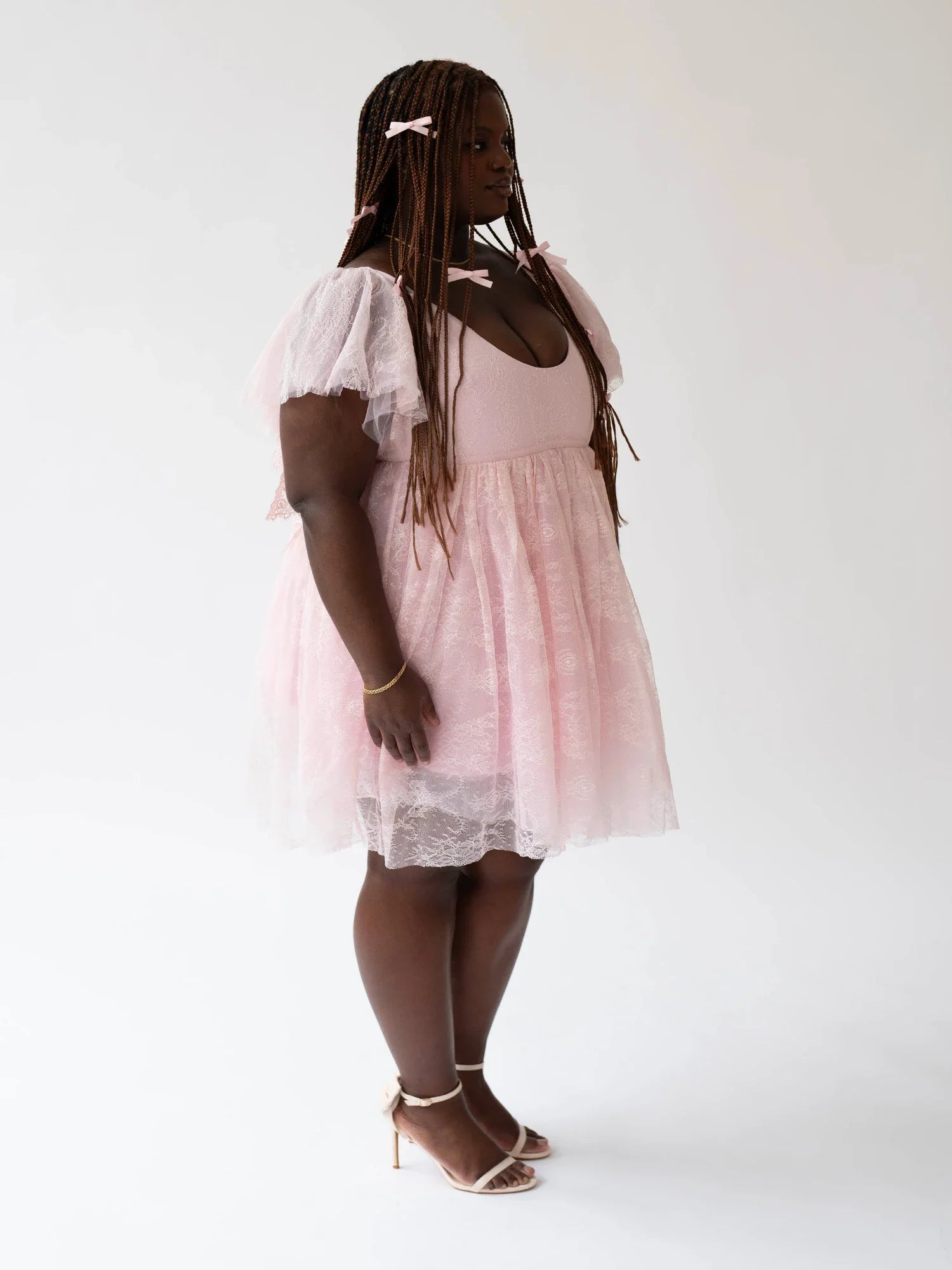 Woman in a light pink cherub dress with white lace trim and hair accessories