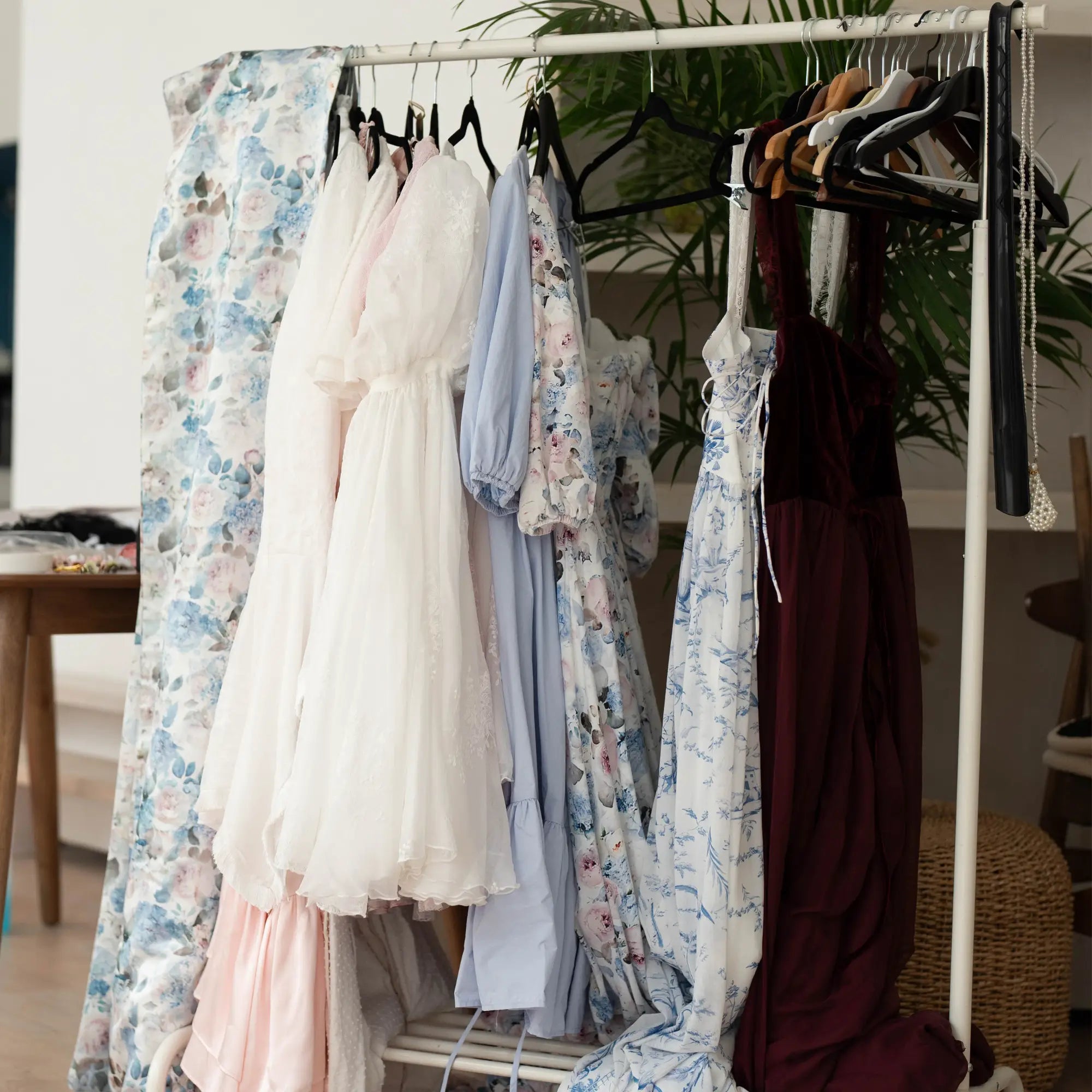 a bunch of victorian inspired women's clothing on a clothing rack.