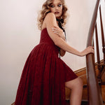 Close up of a woman wearing the Crimson Cathedral Dress standing on a staircase
