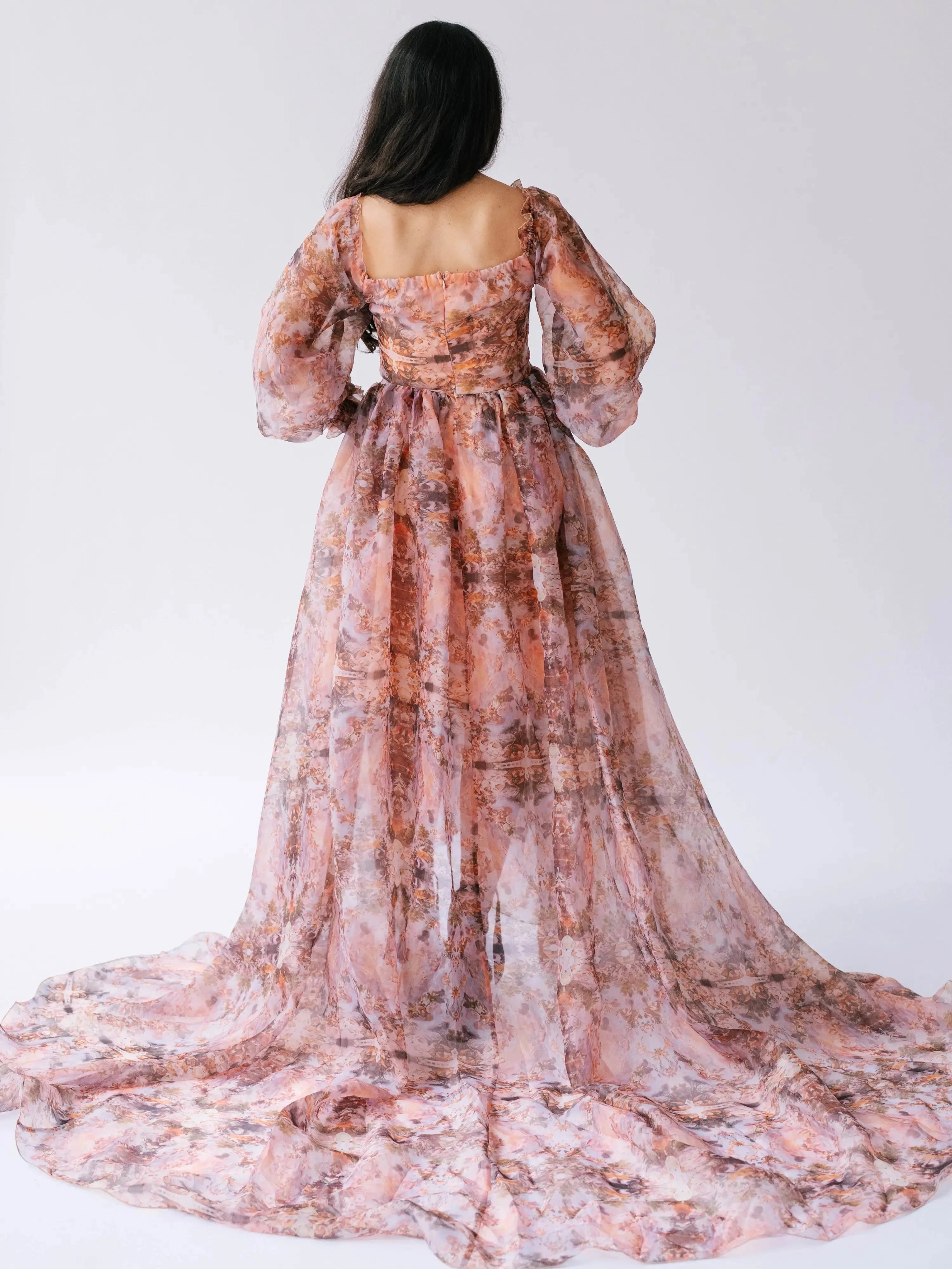 Back view of the Ode to Jove Twilight Reverie Ball Gown showcasing trailing organza and baroque-inspired print on sheer fabric.